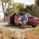 Man in manual wheelchair holding a basketball sitting next to BraunAbility Chevy Traverse with the ramp door open